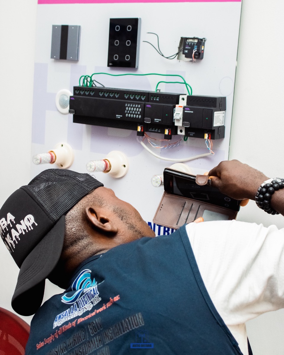 Arctic Controls trainee wiring an HDL Buspro practice board and pairing it to a phone